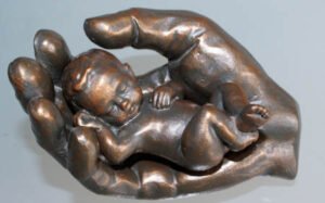Bronzefigur: Baby geborgen in Hand, veranschaulicht Fürsorge um meine Patienten bei der Hypnosetherapie in Mannheim in meiner Hypnosepraxis in Mannheim.